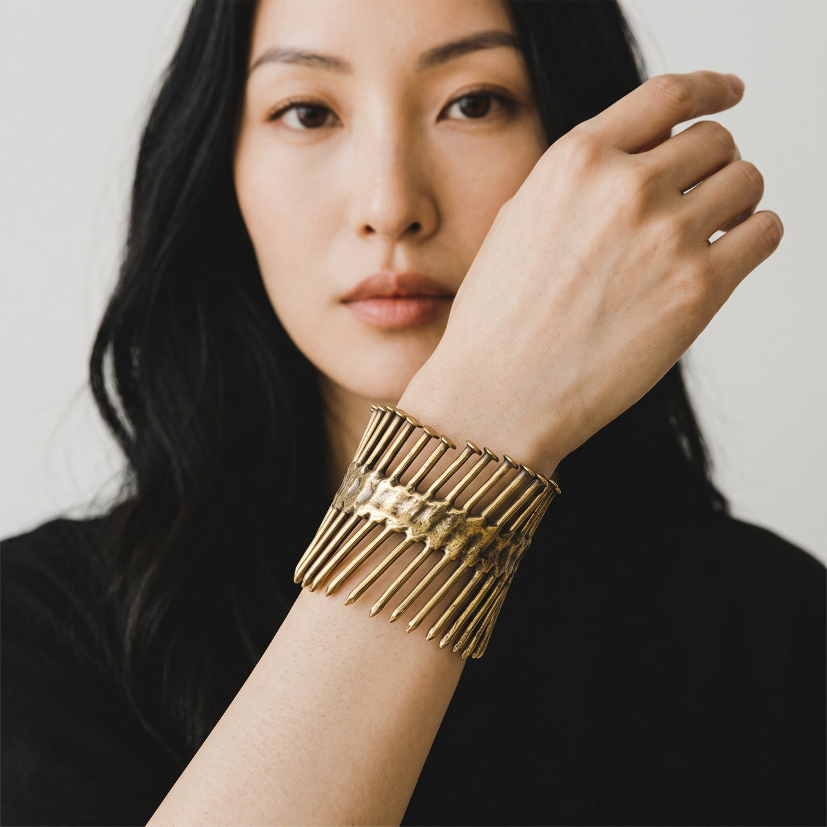Trebor Style Nails Cuff made of reclaimed copper and zinc, worn on a woman's wrist in an industrial, edgy design.
