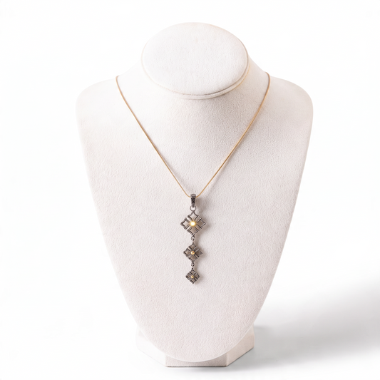 Trebor Style triple drop pendant necklace in oxidized sterling silver and 14k gold on a white display bust.