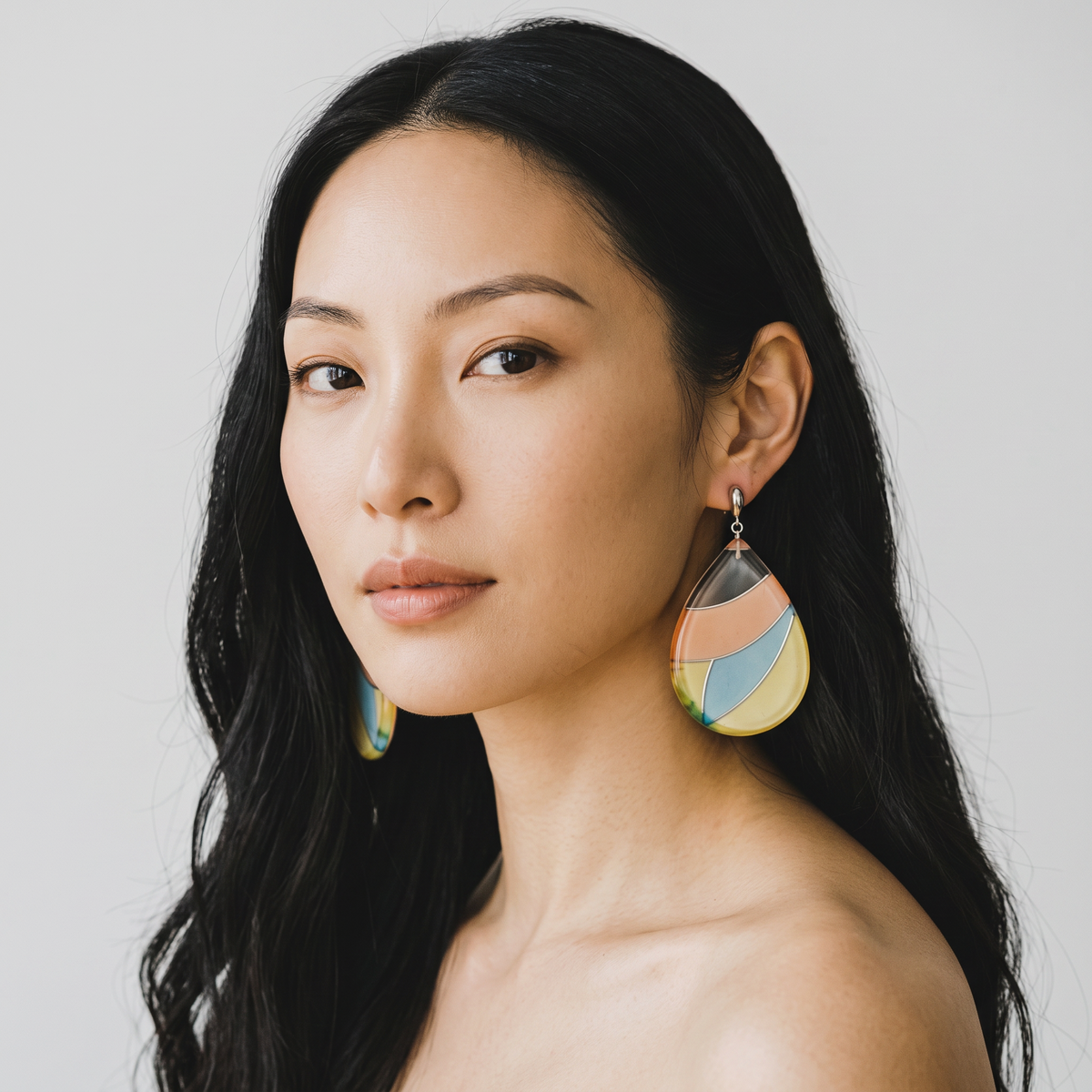 Trebor Style pastel teardrop earrings featuring silk enclosed in acrylic with sterling silver posts on a model.