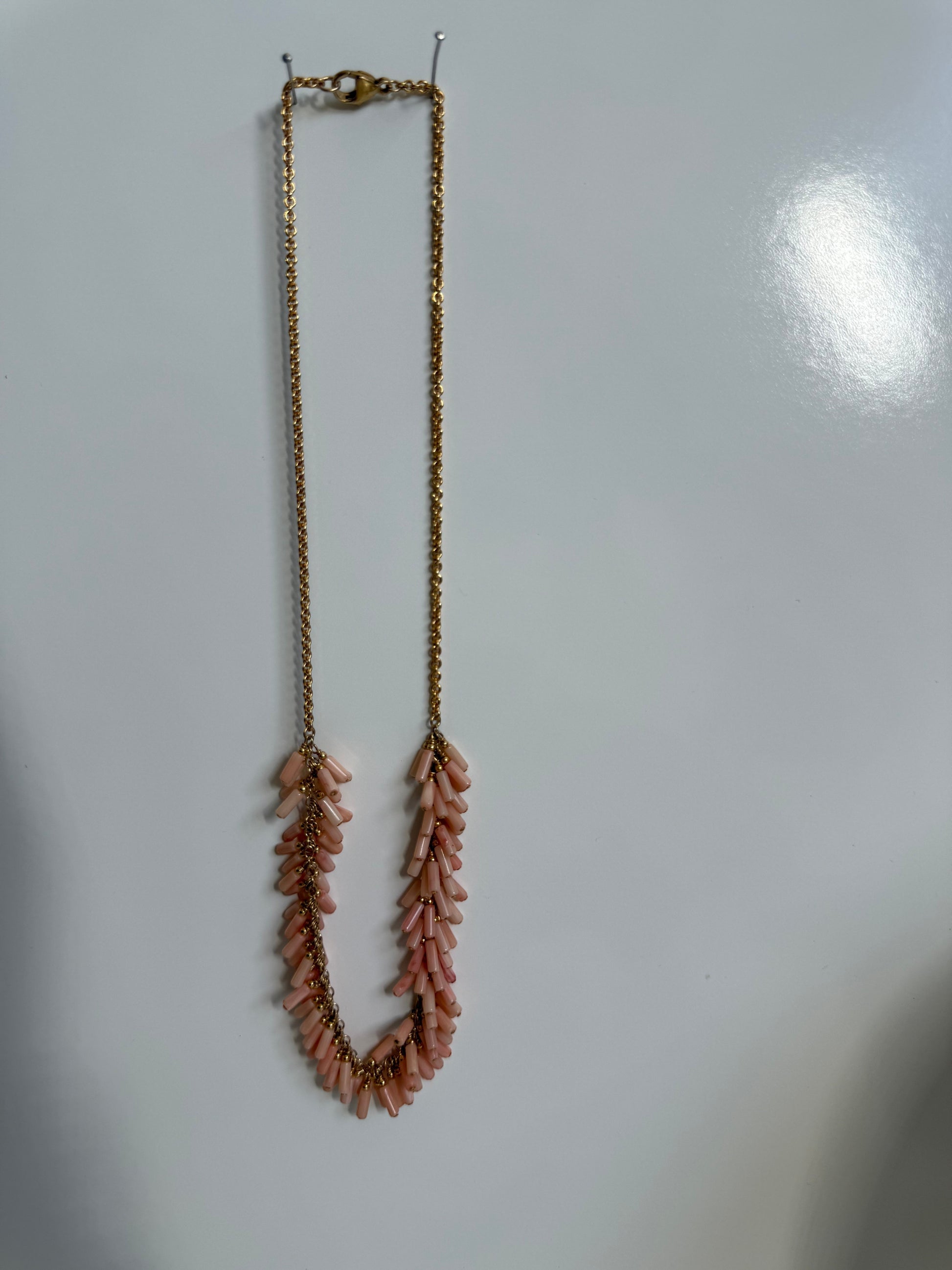 Trebor Style peach coral bead fringe necklace with gold filled chain on a white background
