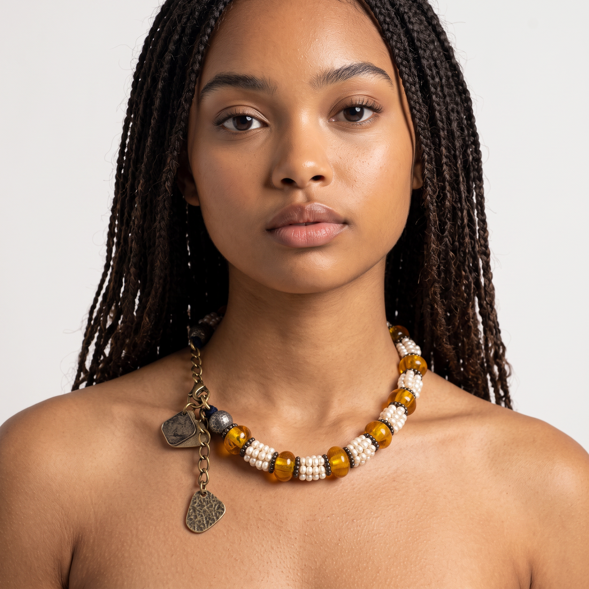 Trebor Style Masha Archer necklace featuring freshwater pearls, Baltic amber, and hammered silver charms on a model.