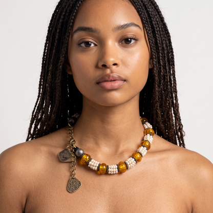 Trebor Style Masha Archer necklace featuring freshwater pearls, Baltic amber, and hammered silver charms on a model.