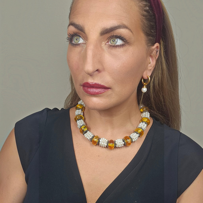 Trebor Style Masha Archer pearl and Baltic amber wreath necklace worn by a woman in a black top