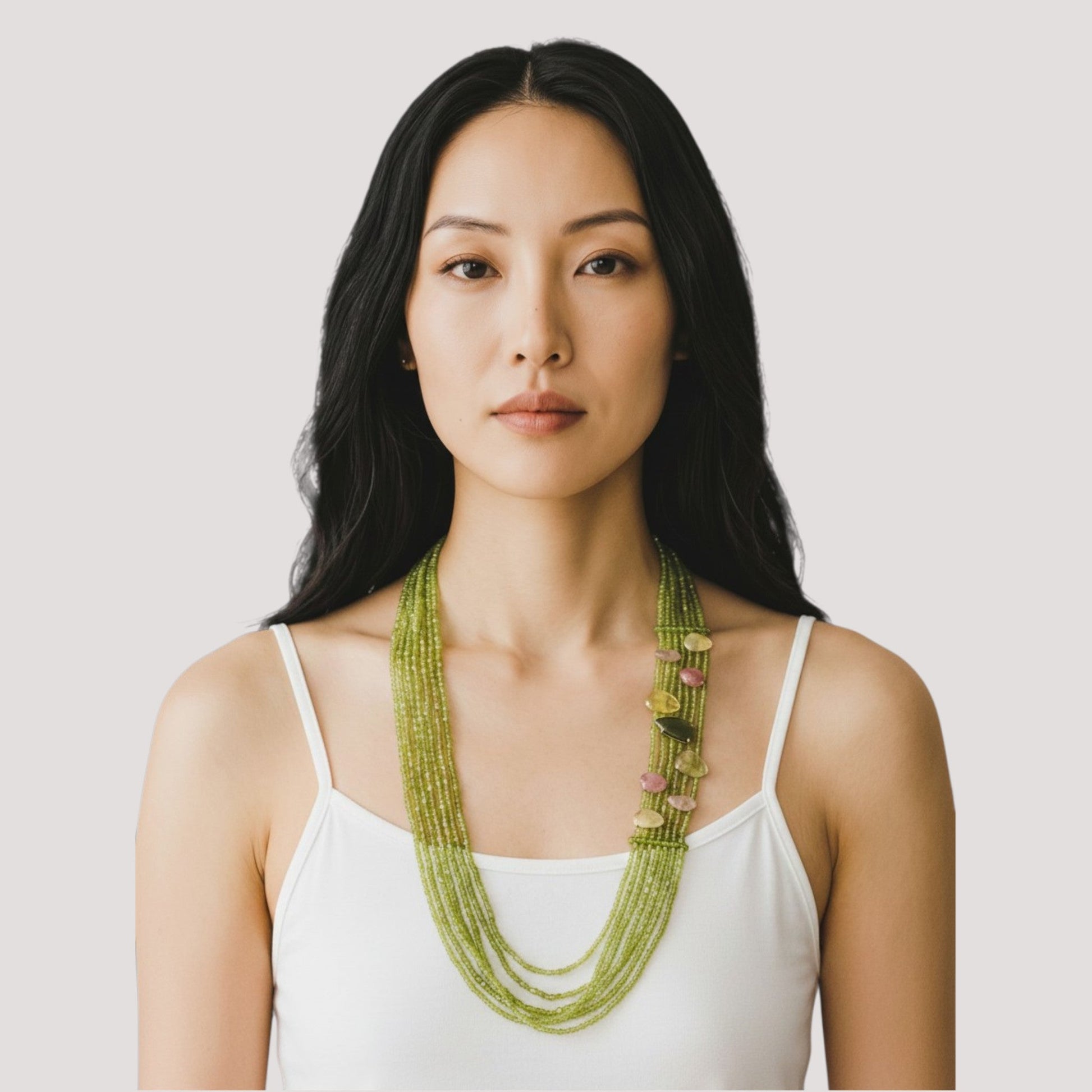 Trebor Style long multi-strand green peridot necklace with pink and yellow sapphire accents worn by a woman