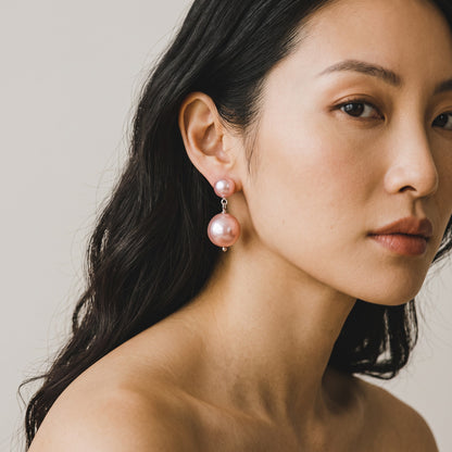 Trebor Style Kate earrings featuring two stacked pink pearls on silver-plated sterling silver posts on a model