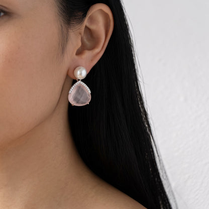 Trebor Style earrings featuring a white pearl, faceted pink quartz drop, and pavé diamonds worn on a woman's ear.