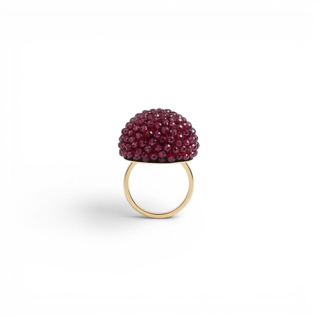 Trebor Style cocktail ring featuring a sphere of faceted purple garnet beads set on an 18k yellow gold band.