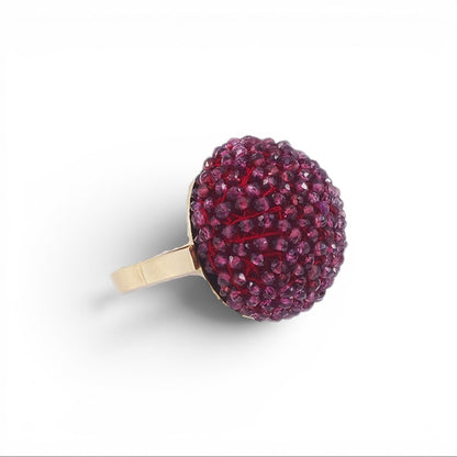 Trebor Style cocktail ring featuring a large sphere of faceted purple garnet beads set on an 18k yellow gold band.