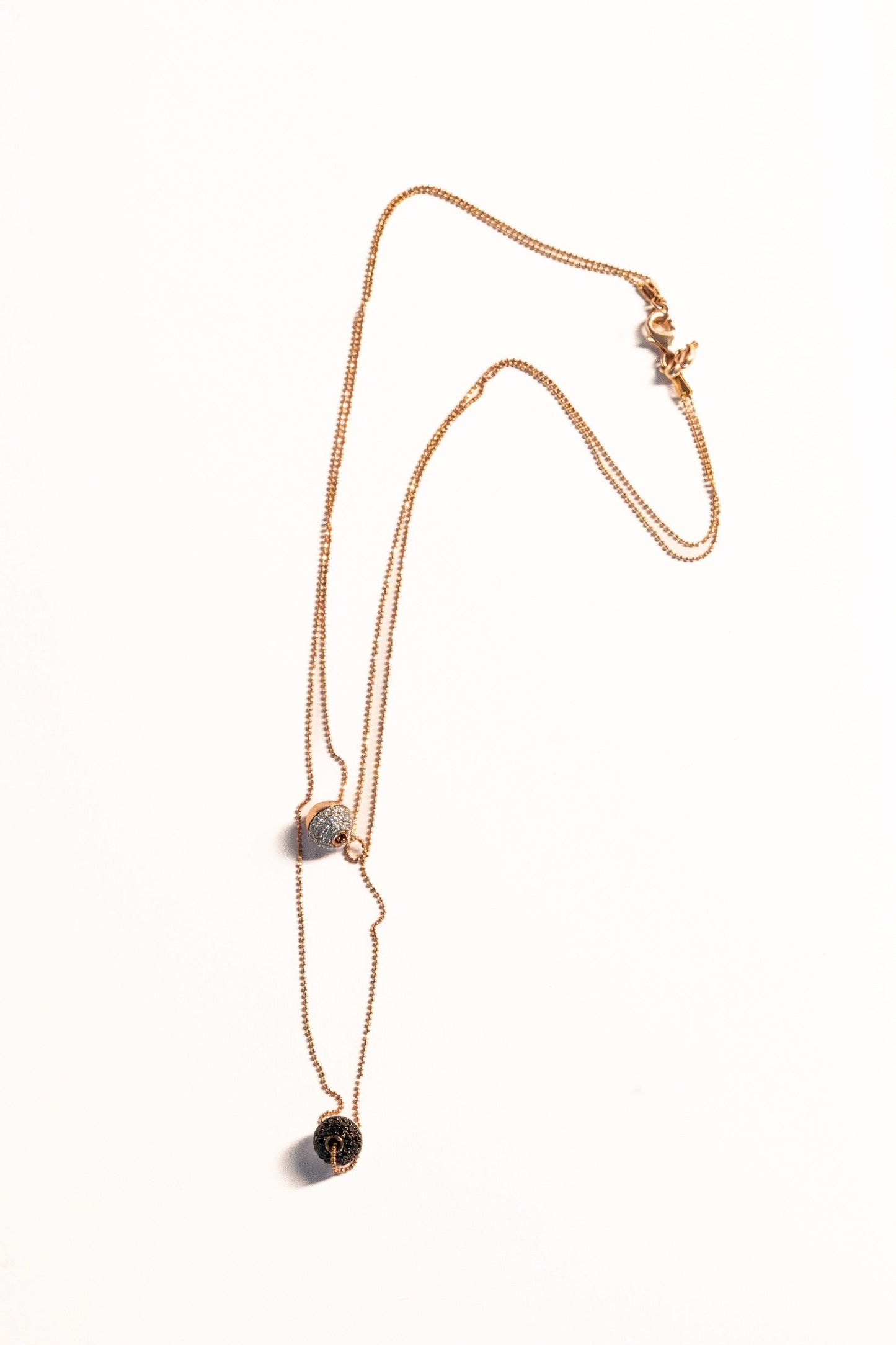 Trebor Style Bronzallure double-strand rose gold necklace with white cubic zirconia and black spinel sphere pendants.