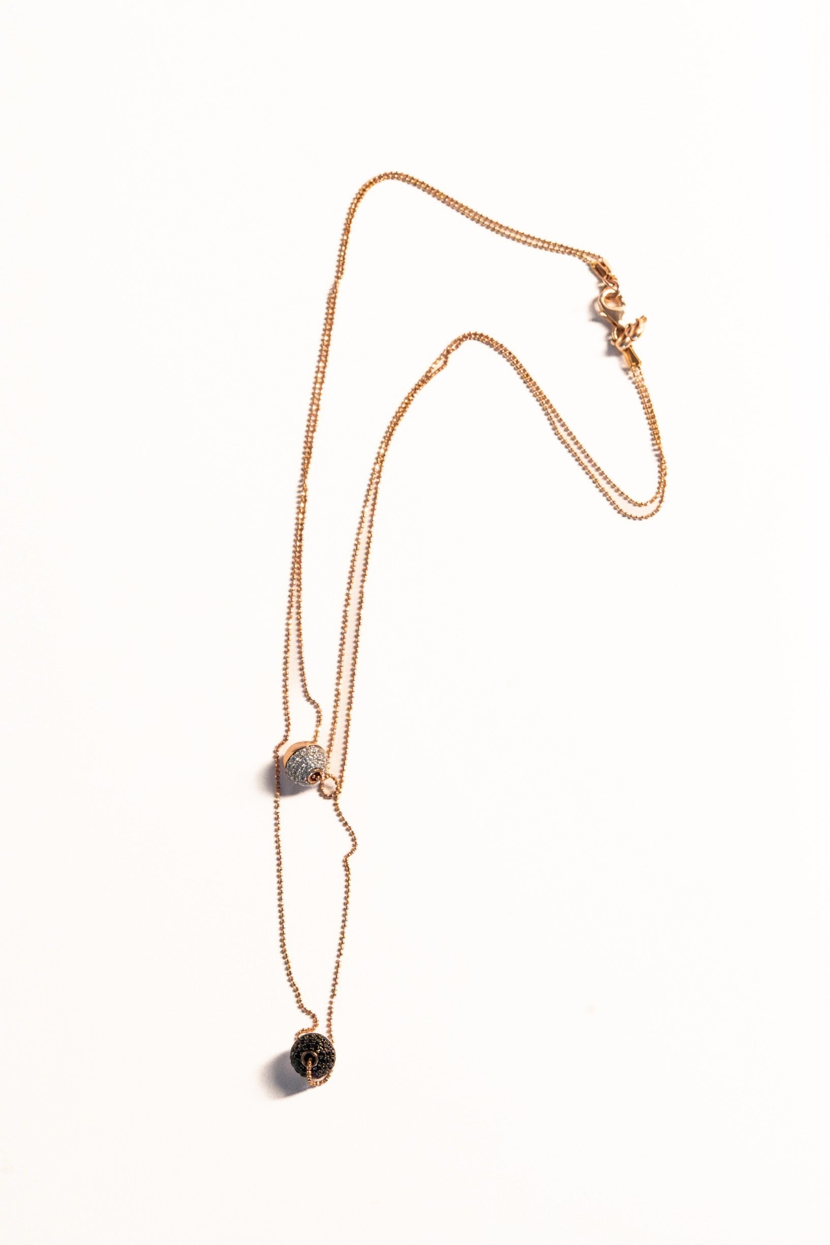 Trebor Style Bronzallure double-strand rose gold necklace with white cubic zirconia and black spinel sphere pendants.