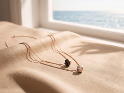 Trebor Style Bronzallure double-strand rose gold necklace with white cubic zirconia and black spinel sphere pendants.
