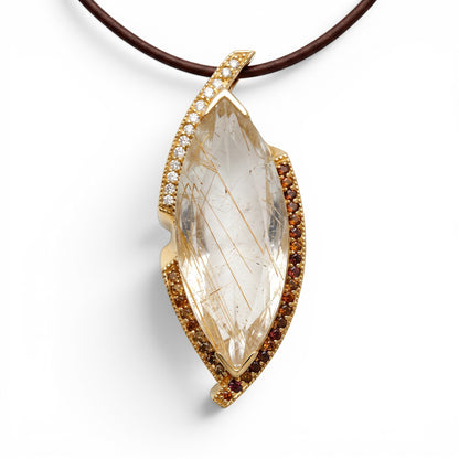 Trebor Style 14k gold pendant featuring a 27ctw rutilated quartz, diamond accents, and garnet stones.
