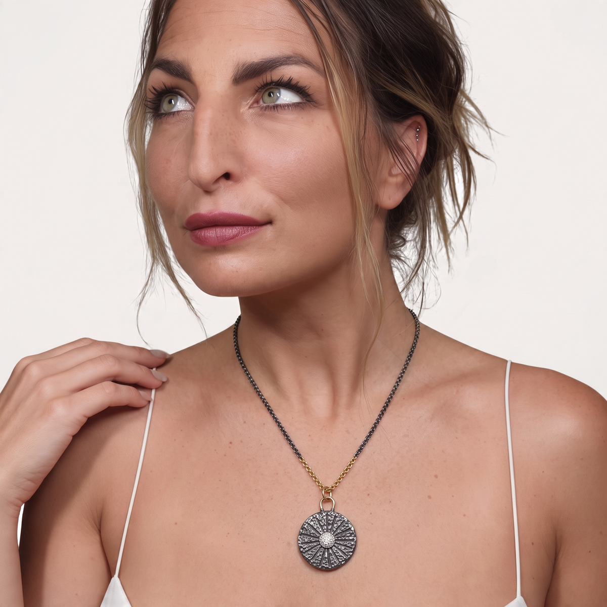Trebor Style sand dollar pendant necklace in oxidized sterling silver and 14k gold with white sapphires on a model