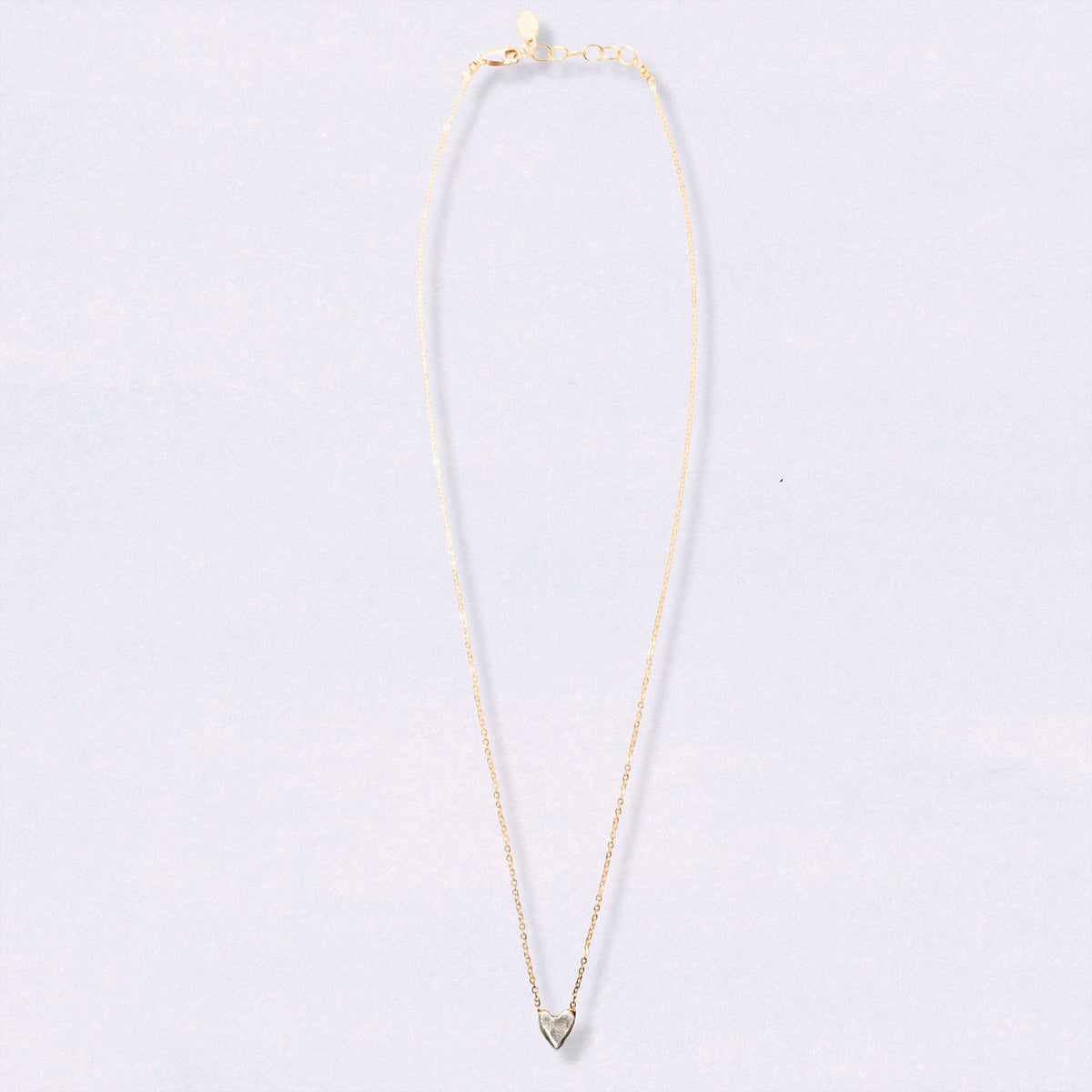 Trebor Style dainty heart necklace featuring a recycled sterling silver heart pendant on a 14kt gold-filled chain.