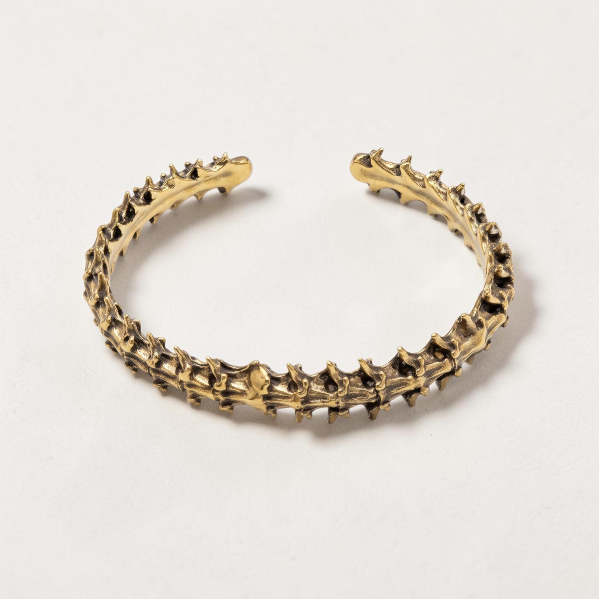 Trebor Style snake vertebrae bangle in reclaimed gold-toned copper and zinc, featuring a unique organic bone texture.