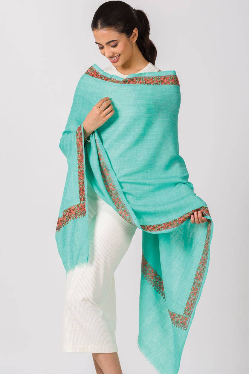 Trebor Style Taisha hand embroidered wool blend shawl in orchid with a floral border draped over a woman's shoulders.