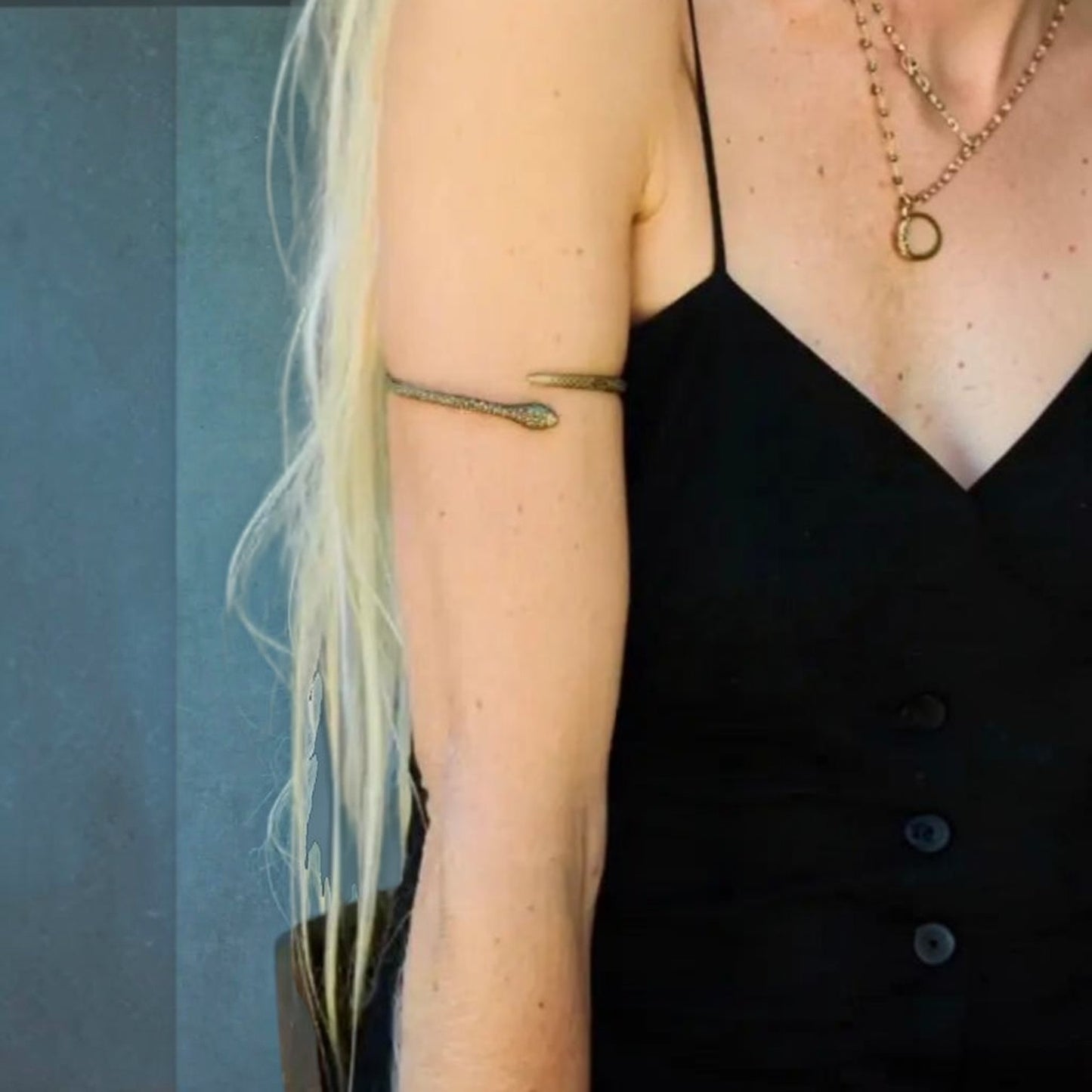 Trebor Style textured gold serpent armband worn on the upper arm by model Kristy Hume against a grey background
