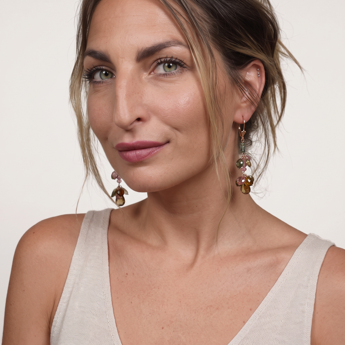 Trebor Style 14k yellow gold dangle earrings featuring multi-color pink and green tourmaline gemstones on a model.