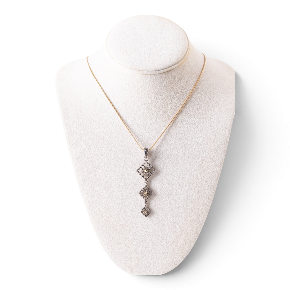 Trebor Style triple drop pendant necklace in oxidized sterling silver and 14k gold on a white jewelry display bust.