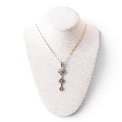 Trebor Style triple drop pendant necklace in oxidized sterling silver and 14k gold on a white jewelry display bust.