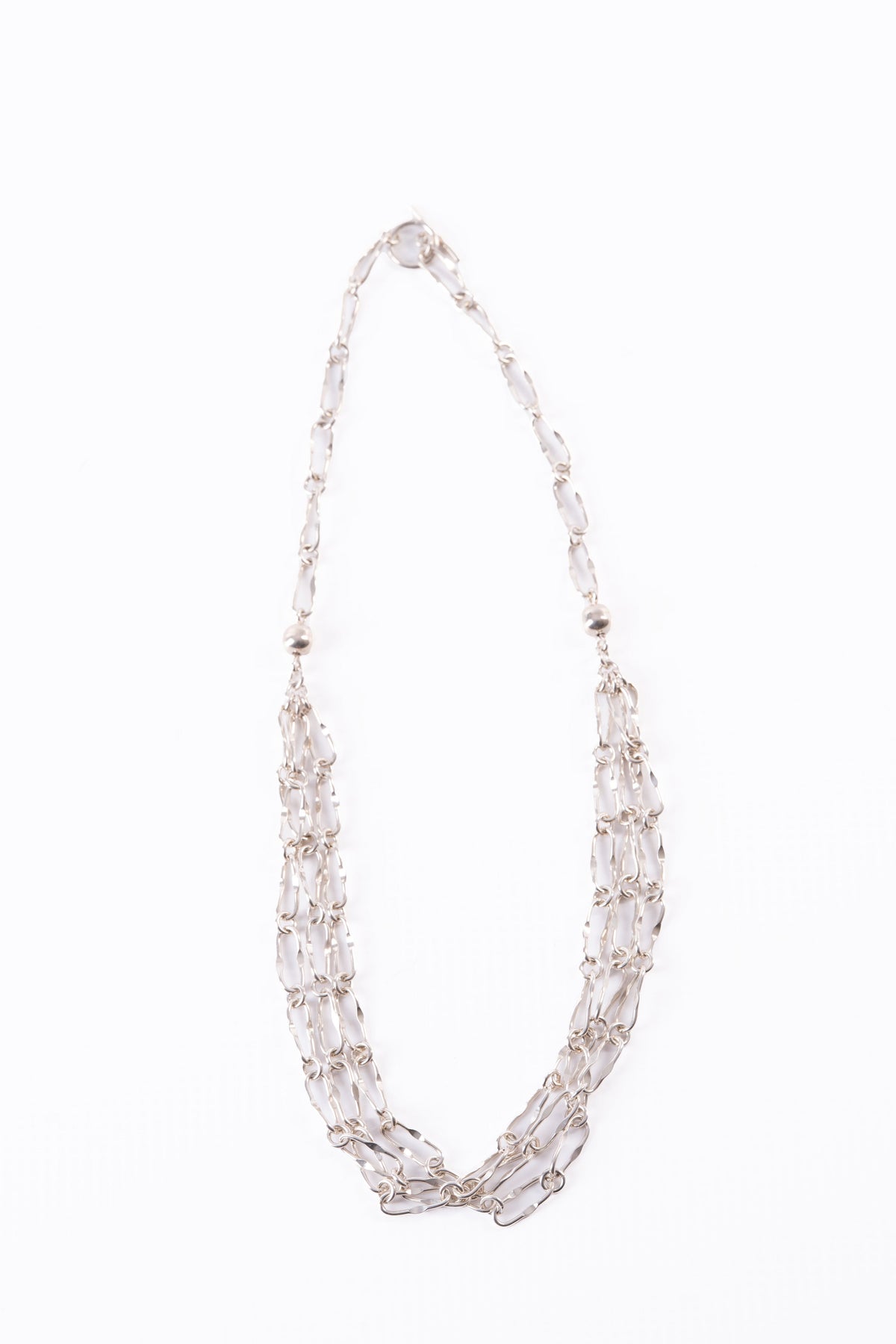 Trebor Style triple strand sterling silver necklace with oblong chain links on a white background.