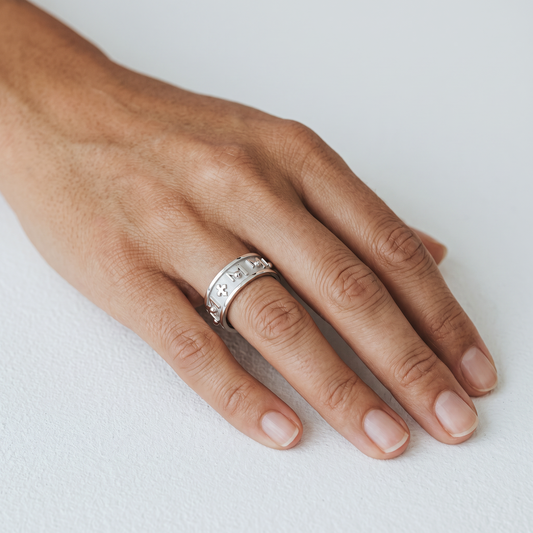 Trebor Style TUUM Decem ring in white rhodium plated sterling silver featuring beaded M symbols and crosses on hand.