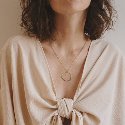 Trebor Style two-tone circle pendant necklace featuring gold-filled and oxidized silver wire-wrapped mixed metal design