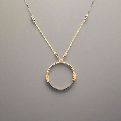 Trebor Style two-tone circle pendant necklace with 14K gold-filled and oxidized sterling silver wire-wrapped detail.