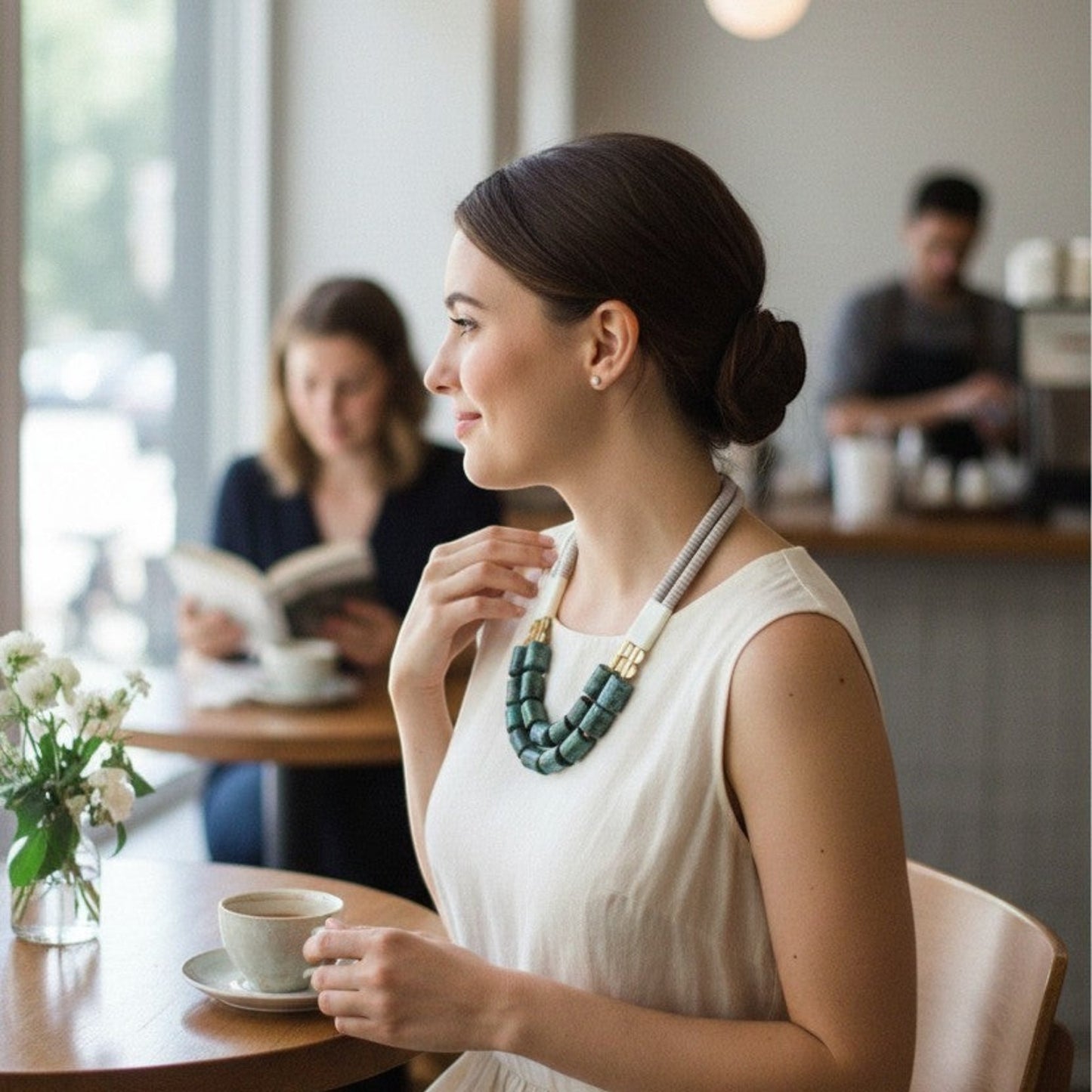 Trebor Style VRD121 21-inch necklace featuring magnesite, aventurine, brass, and turquoise beads on a woman in a cafe.