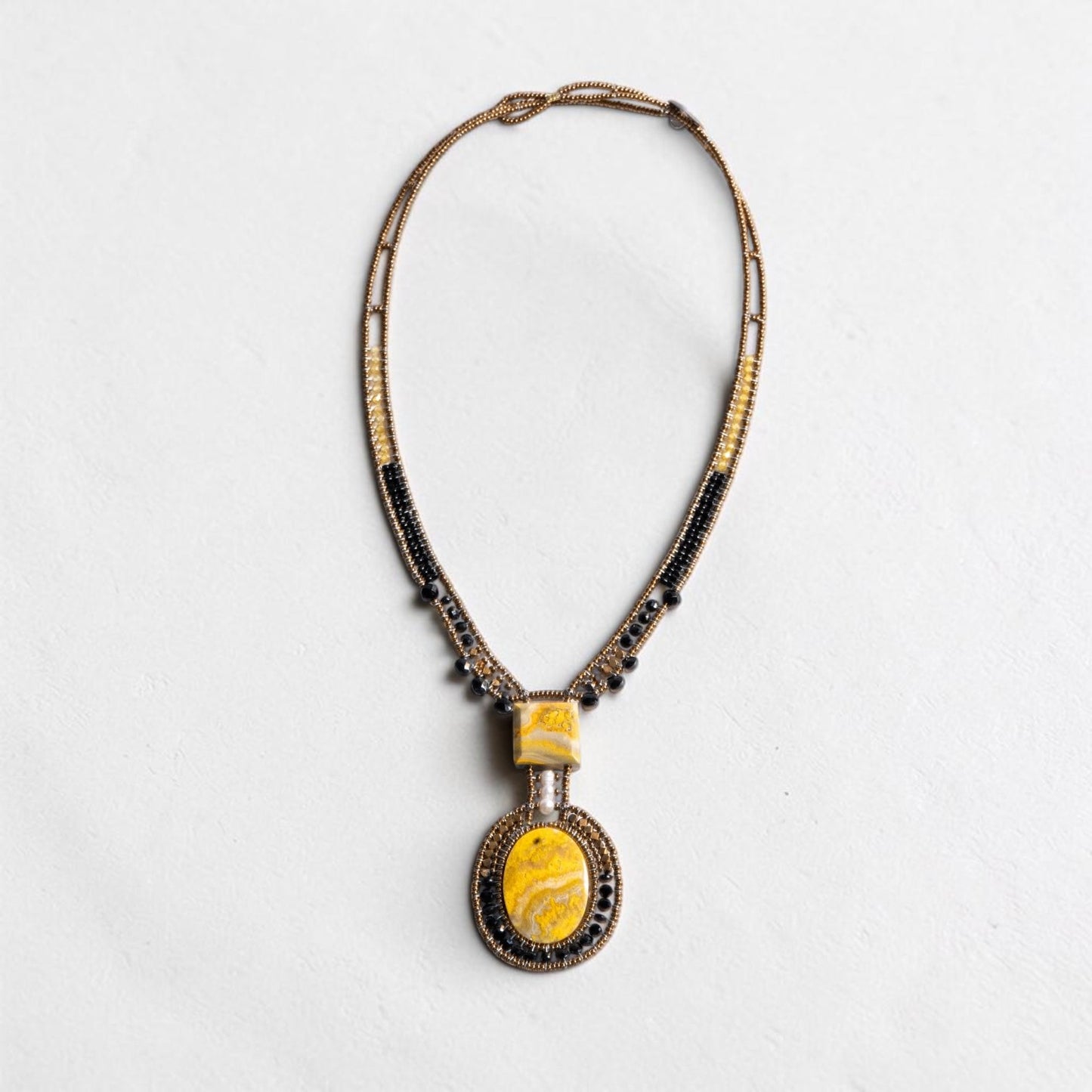 Trebor Style artisan statement necklace featuring yellow jasper, black glass beads, and a white pearl pendant.