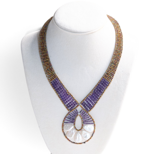 Trebor Style Ziio Ariane necklace featuring a Mother of Pearl fan pendant, amethyst beads, and Murano glass seed beads.