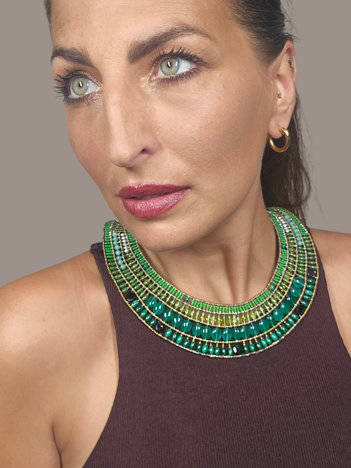Trebor Style Ziio Fenice collar necklace featuring green gemstones and Murano glass beads worn by a woman.