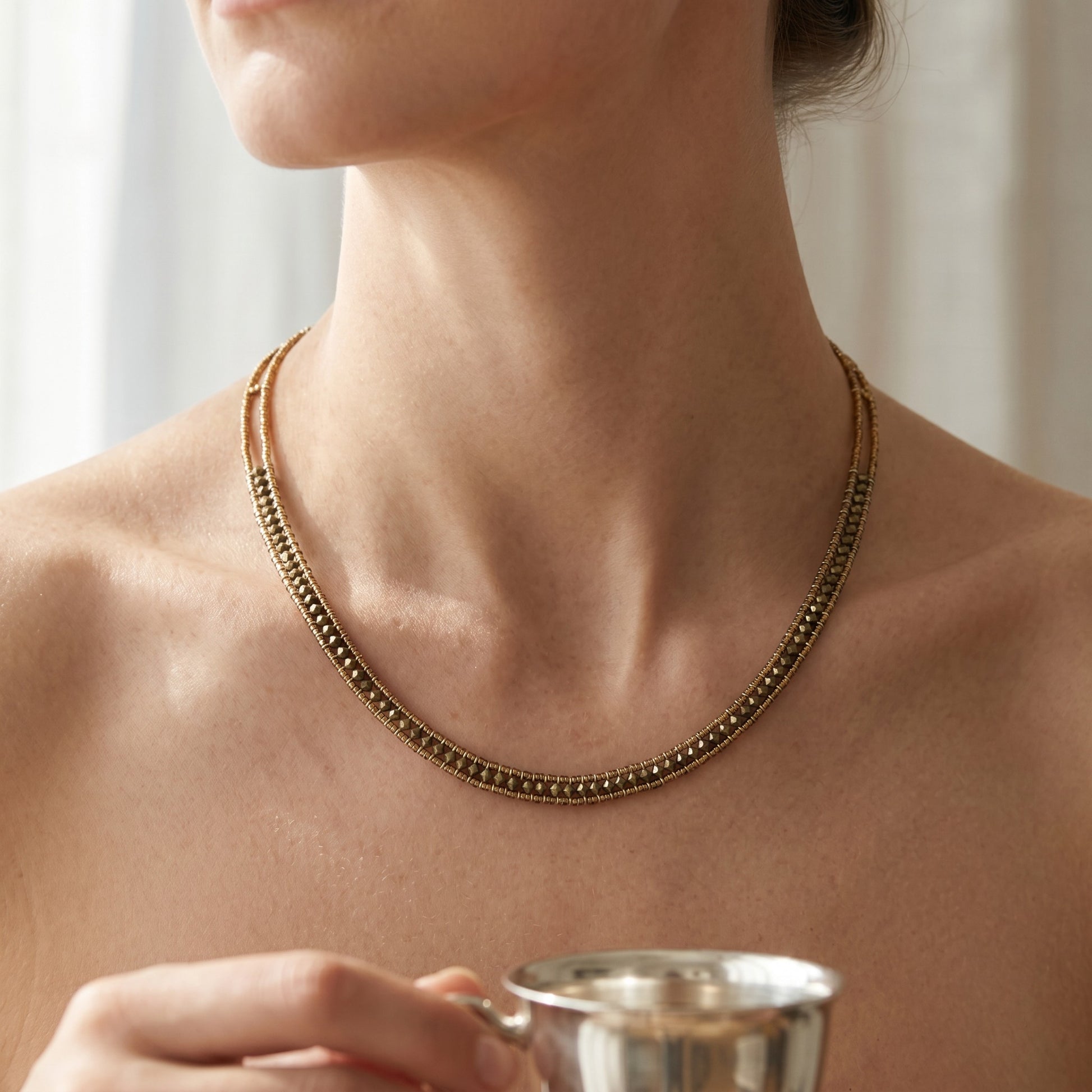 Trebor Style Ziio narrow Giro necklace featuring hunter green zircon gemstones and Murano glass beads on a model.