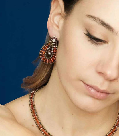 Trebor Style Ziio oval drop earring featuring red zircon, garnet, and Murano glass beads on a model
