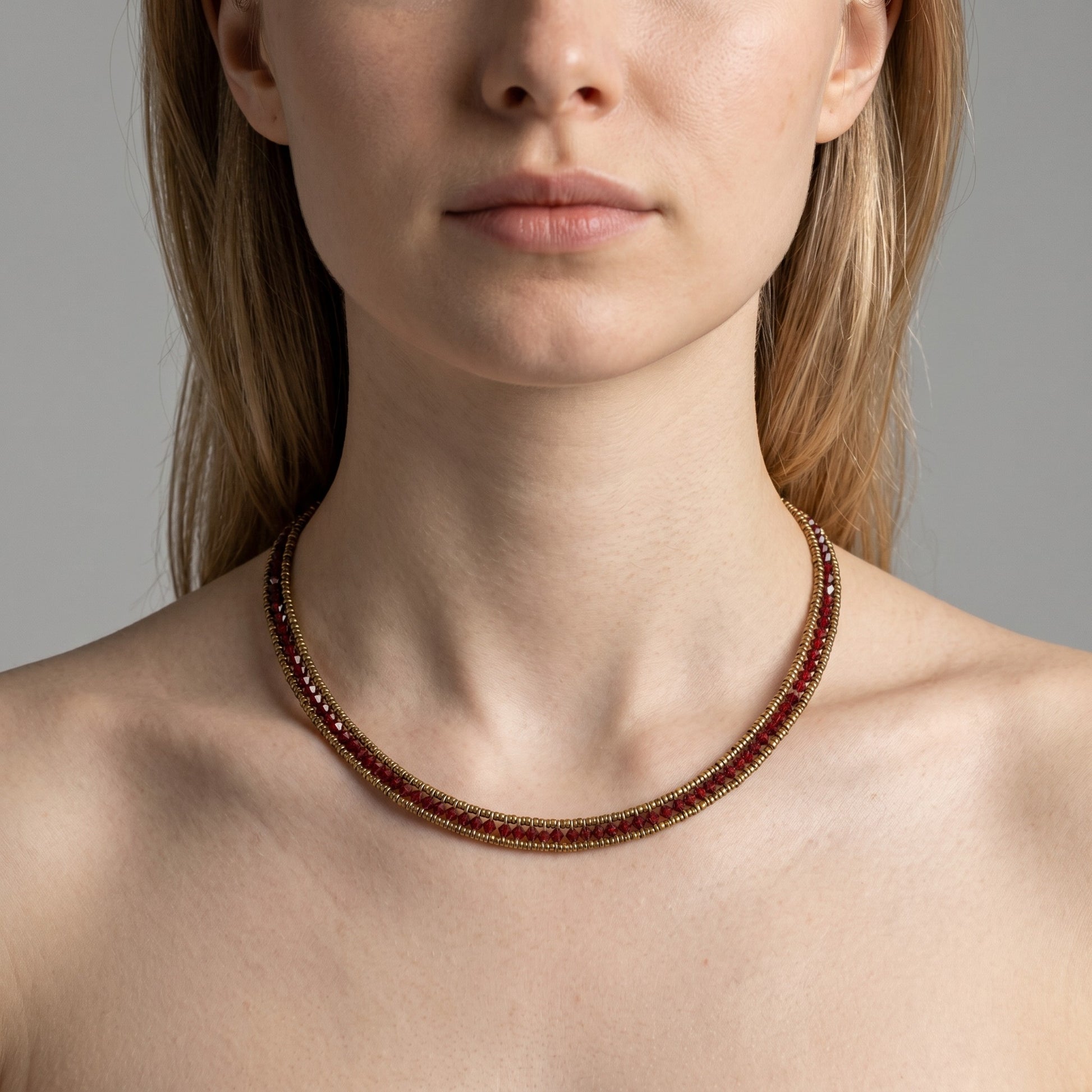 Trebor Style Ziio narrow Giro necklace featuring sparkling red zircon gemstones and Murano glass beads on a model.