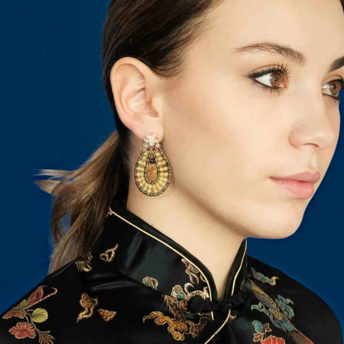 Trebor Style Ziio oval drop earring featuring yellow zircon, citrine, and Murano glass beads on a model